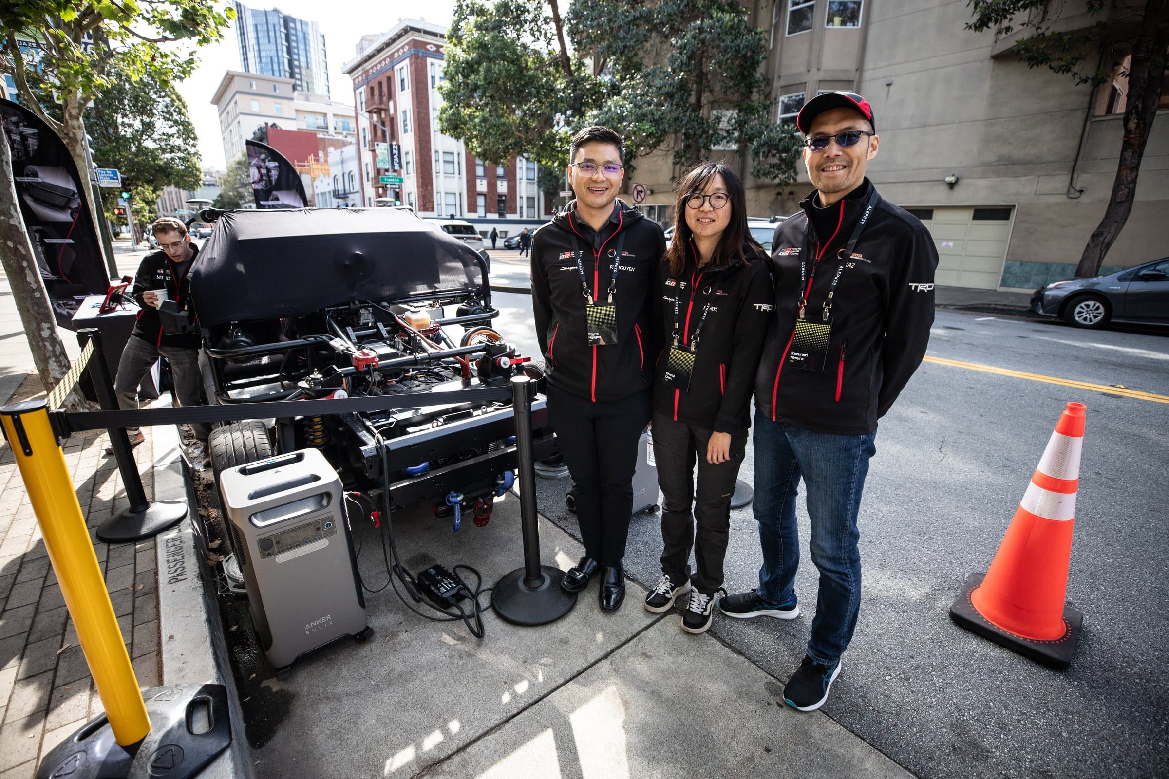 Ride AI team posing beside the Toyota Research Institute vehicle demo